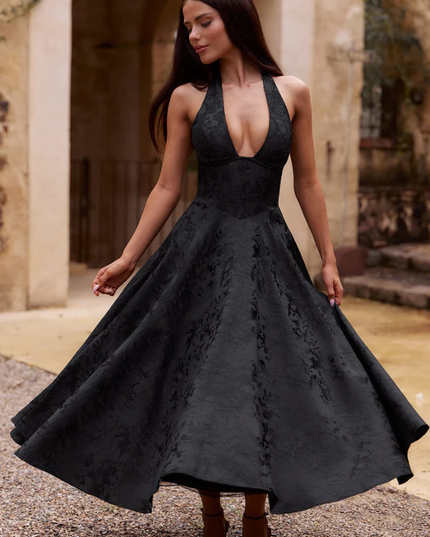 Black jacquard midi dress with a halter v-neck, full skirt, and subtle floral pattern, for prom or formal events.