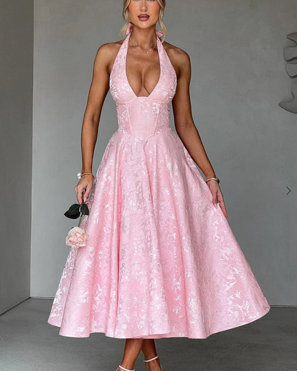 Full shot of a pink jacquard midi dress, highlighting the intricate pattern and halter design.