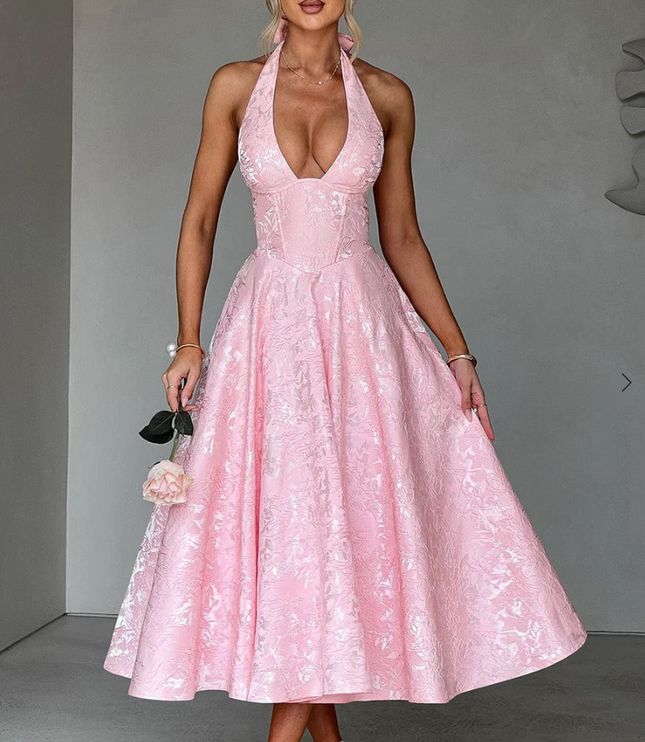 Full shot of a pink jacquard midi dress, highlighting the intricate pattern and halter design.