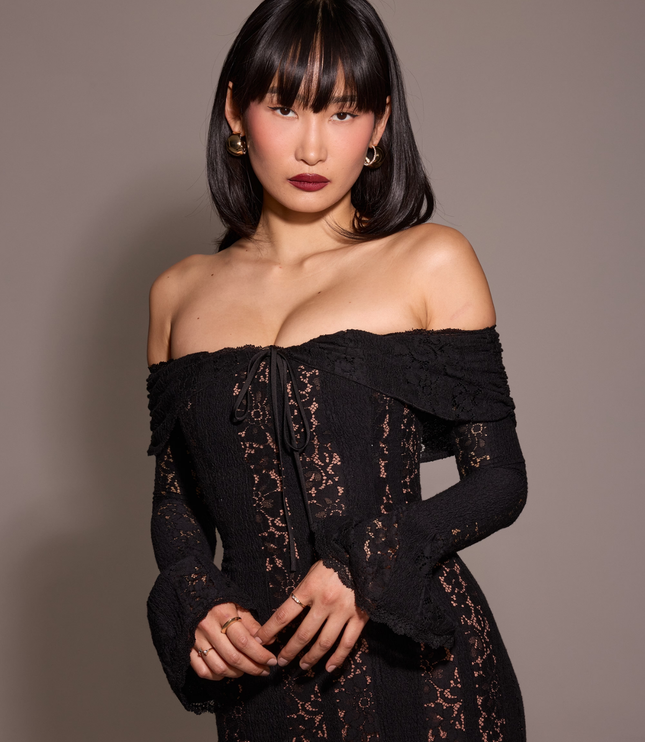 Close-up of a women's black off-shoulder floral lace maxi dress, focusing on the neckline and lace pattern.