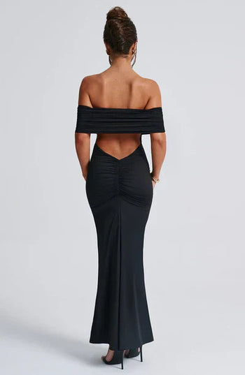 Back view of a black off-shoulder maxi dress, showcasing the ruched back detail and elegant V-shaped cut-out.