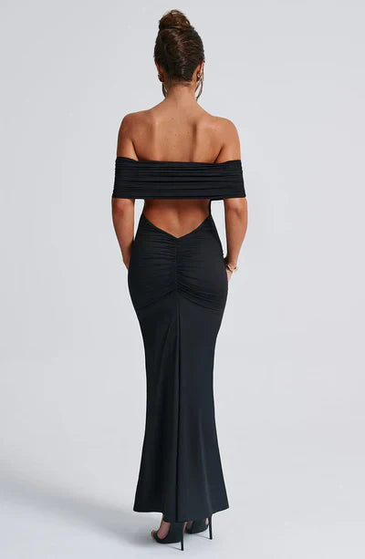 Back view of a black off-shoulder maxi dress, showcasing the ruched back detail and elegant V-shaped cut-out.