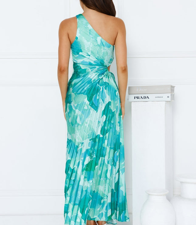 Back view of the women's one shoulder cutout maxi dress in a striking blue and green floral print with a pleated skirt.