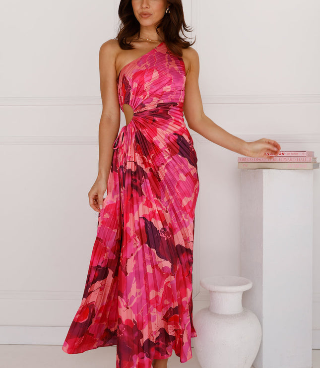 Women's one shoulder cutout pleated maxi dress in a vivid pink and red floral pattern, with a flowing skirt.