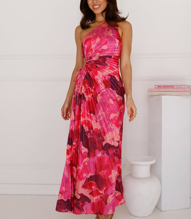 Women's elegant one shoulder maxi dress in a fuchsia and crimson floral print, featuring a pleated skirt and waist cutout detail.