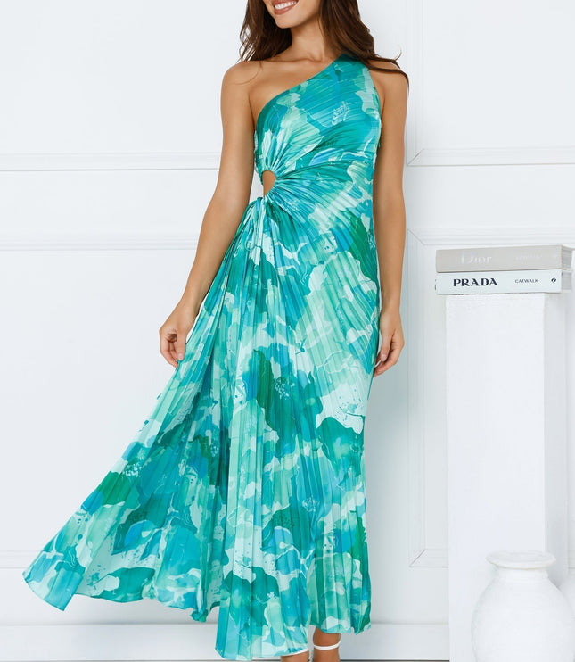 Women's one shoulder cutout pleated maxi dress in a vibrant blue and green floral pattern, flowing gracefully.