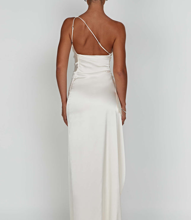 Back view of a women's ivory one shoulder maxi dress, showing the delicate strap and flowing skirt.
