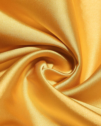 Textured close-up of the lustrous yellow satin fabric, suitable for a women's prom dress.