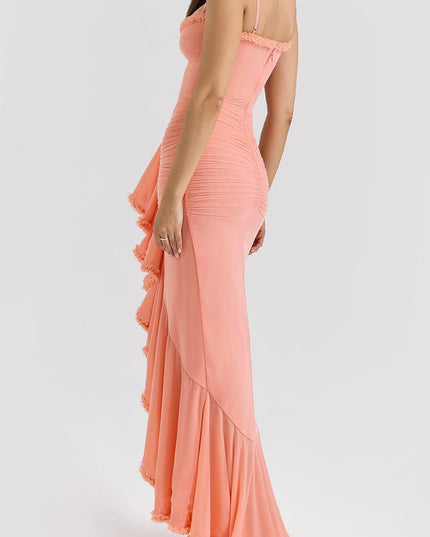 Three-quarter rear view of a peach women's prom maxi dress with intricate ruching and a ruffled high-low hemline.