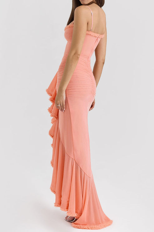 Three-quarter rear view of a peach women's prom maxi dress with intricate ruching and a ruffled high-low hemline.