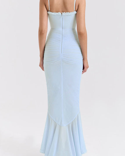 Back view of a women's light blue prom dress with spaghetti straps, ruched detailing, and a flowing ruffled hem.
