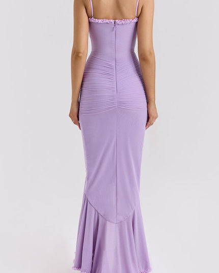 Back view of a light purple maxi dress with ruched detailing on the bodice and a ruffled hemline.