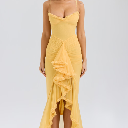 Full-length women's prom ruffled front maxi dress in vibrant yellow with spaghetti straps and ruched bodice, paired with nude heels.