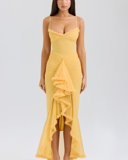 Full-length women's prom ruffled front maxi dress in vibrant yellow with spaghetti straps and ruched bodice, paired with nude heels.