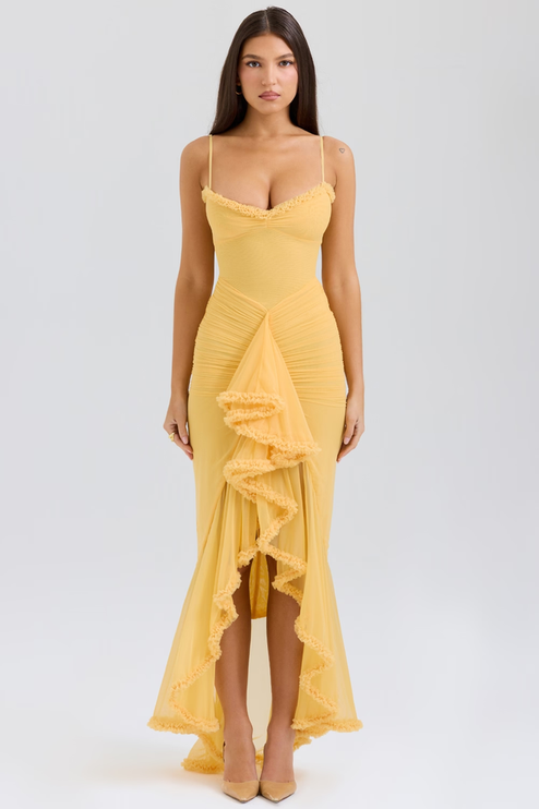 Full-length women's prom ruffled front maxi dress in vibrant yellow with spaghetti straps and ruched bodice, paired with nude heels.