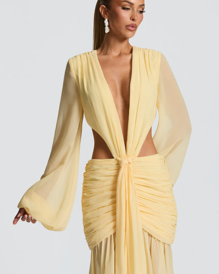 Close-up of the bodice of a light yellow prom maxi dress with deep V-neck, long sheer sleeves, and knotted front.