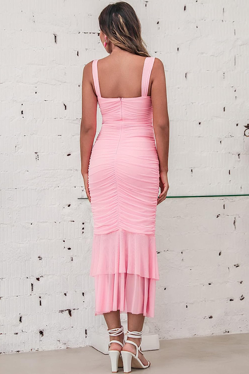 Rear view of a pink ruched fishtail maxi dress, displaying the full length and ruffled sheer hem.