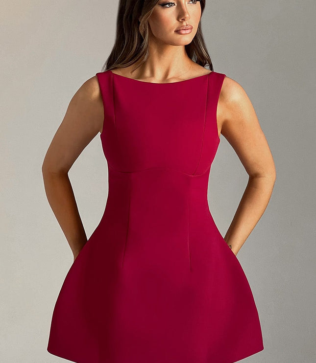Front view of a women's red high neck bubble mini dress with a fitted bodice and flared skirt, hands in pockets.