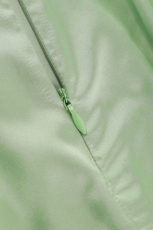 Close-up of the light green zipper detail on the side of a satin cowl neck mini romper.