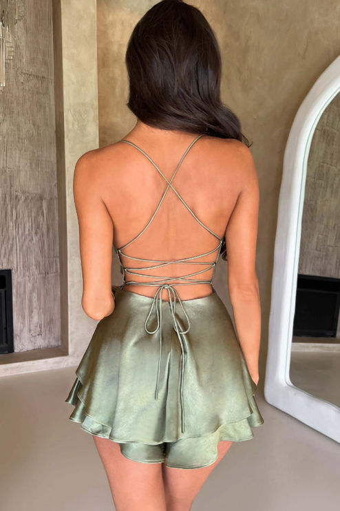Rear view of a women's olive green satin backless mini romper, highlighting the intricate lace-up back design.