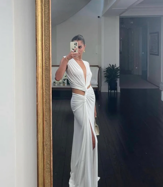 White sleeveless halter V-neck maxi dress with side cut-outs and a high slit, selfie in a mirror.