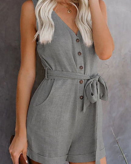 Front view of a women's grey sleeveless V-neck romper, showcasing the tie waist, buttons, and cuffed shorts.