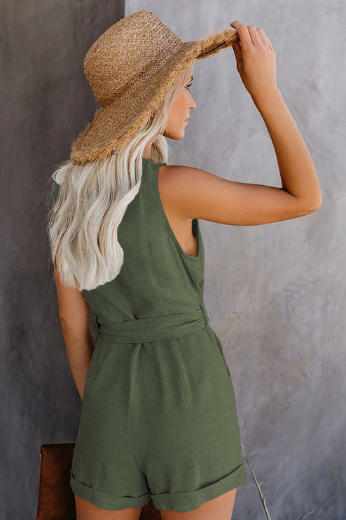 Back view of a women's sleeveless olive green V-neck romper with a tie waist and rolled shorts.