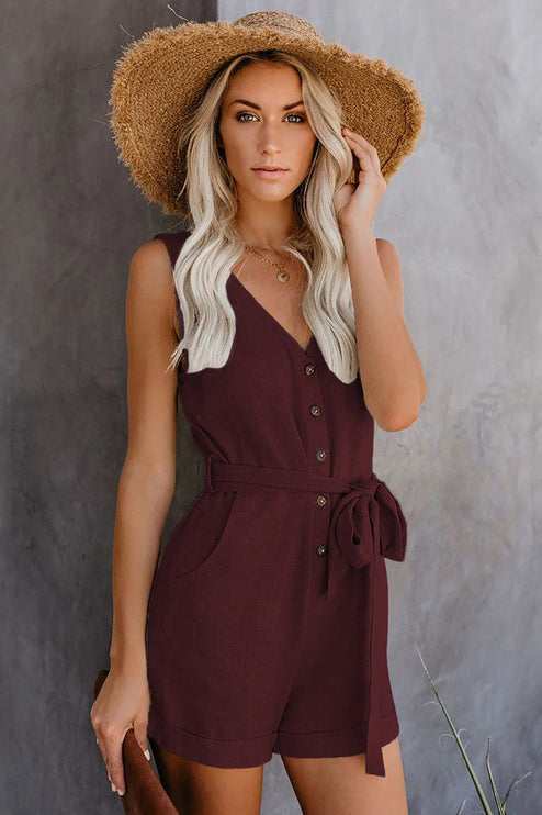 Front view of a women's sleeveless V-neck romper in deep burgundy with a tie waist and visible buttons.