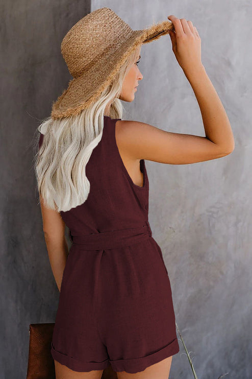 Back view of the women's burgundy sleeveless romper, showing the tie waist and cuffed shorts design.