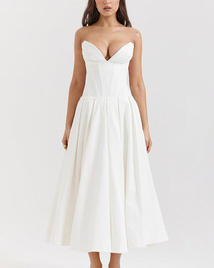 Front view of a white strapless midi dress with a boned bodice and pleated skirt, paired with white heels.