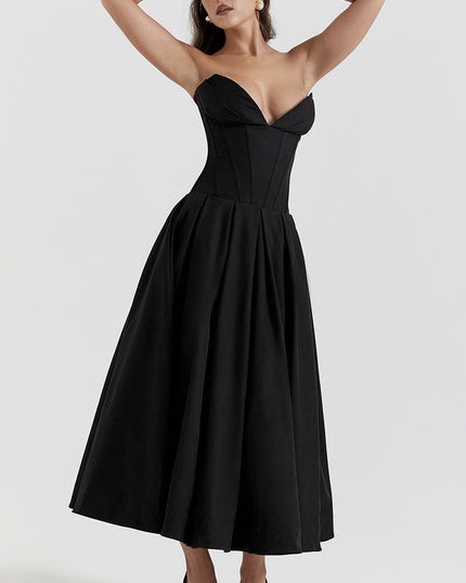 Elegant black strapless boned bodice midi dress, pleated skirt, woman posing with hands above head.