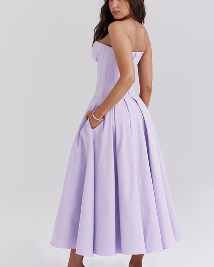 Three-quarter back view of women's lavender strapless boned bodice pleated midi dress with pockets