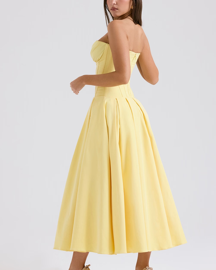 Three-quarter view of a yellow strapless boned bodice pleated midi dress, showcasing the full skirt and pleats.