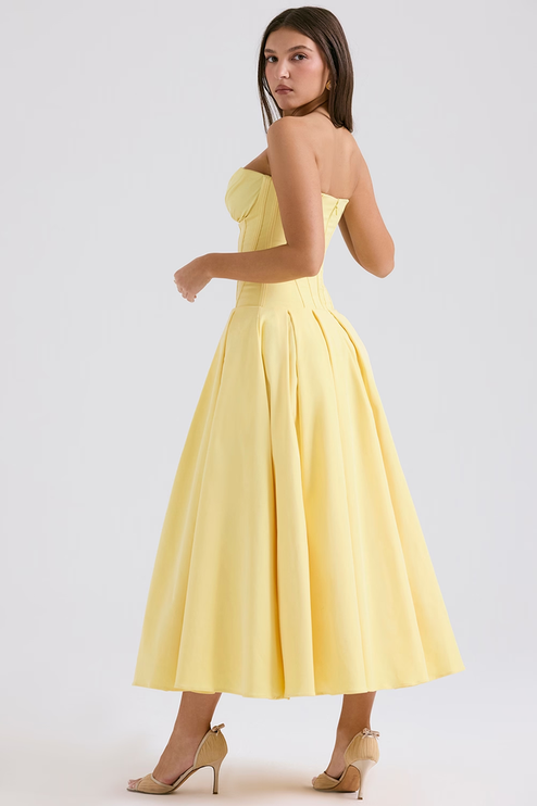 Three-quarter view of a yellow strapless boned bodice pleated midi dress, showcasing the full skirt and pleats.