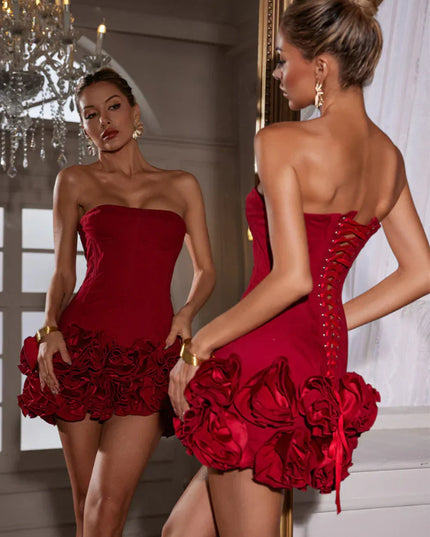 Woman in a red strapless corset mini dress, showcasing the back lace-up detail and ruffled skirt.