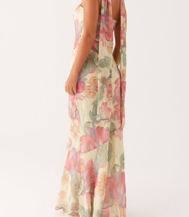 Three-quarter back view of the women's floral strapless maxi dress, showing the flowing scarf and delicate floral print.