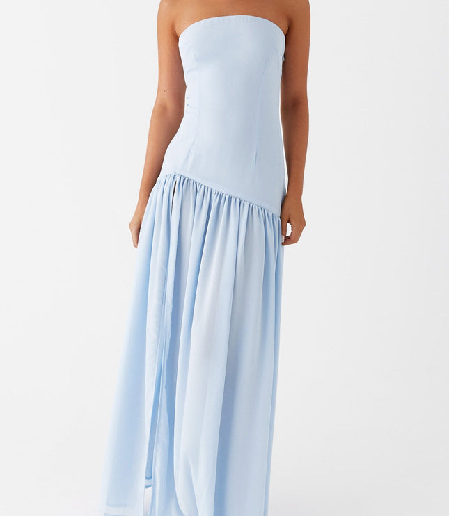 Angled front view of the light blue strapless maxi dress, featuring a subtle side slit and gathered skirt.