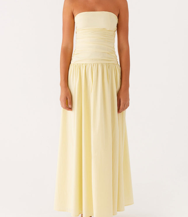 Front view of a light yellow strapless ruched maxi dress with a gathered drop waist.