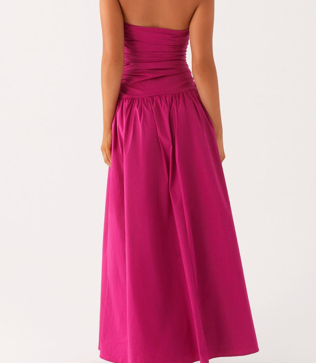 Back view of a women's fuchsia strapless ruched maxi dress, highlighting the drop waist and full skirt.
