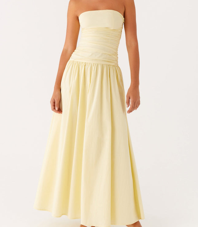 Full body view of the women's strapless ruched drop waist maxi dress in a soft yellow hue.