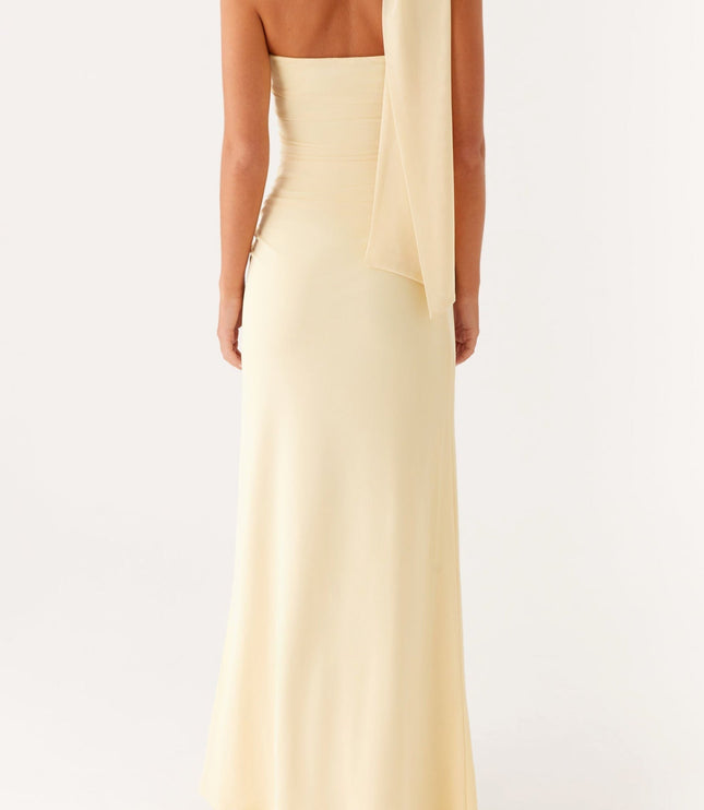 Back view of a women's pale yellow strapless maxi dress, showing the draped scarf detail from behind.