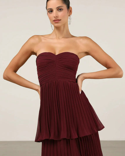 Close-up of the bodice and upper tiers of the burgundy strapless pleated maxi dress, showing fabric texture.
