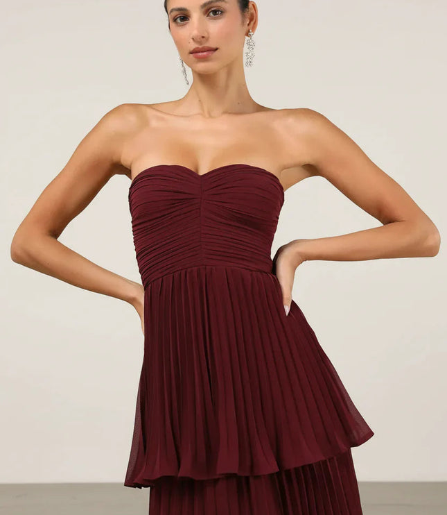 Close-up of the bodice and upper tiers of the burgundy strapless pleated maxi dress, showing fabric texture.