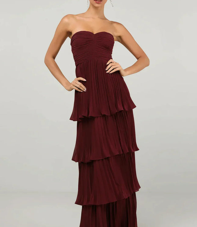 Front view of a women's strapless tiered pleated maxi dress in a rich burgundy color, with a ruched bodice.
