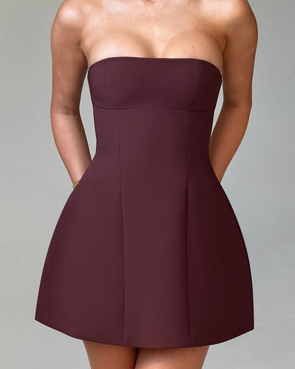 Detailed view of the dark brown strapless mini dress, emphasizing the bustline and skirt pleats.