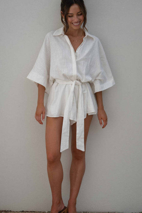 Full front view of a women's white summer collared short romper with wide sleeves and a self-tie waist.