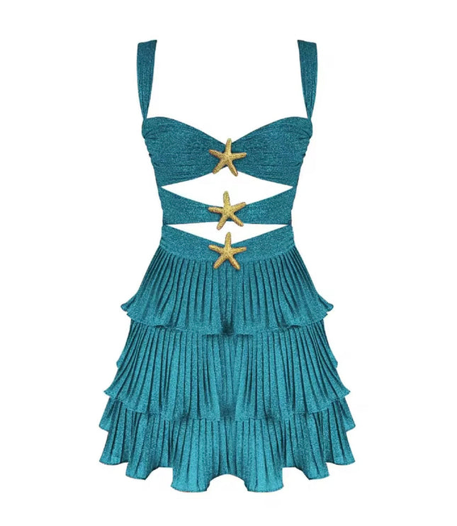 Studio shot of a women's shimmery blue summer cut out mini dress with tiered ruffles and gold starfish details.