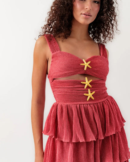 Close-up of women's coral summer mini dress with cut-outs and three gold starfish embellishments.