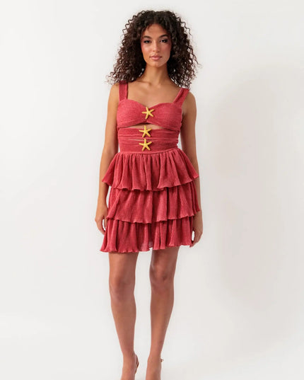 Full view of women's coral summer cut out mini dress with tiered ruffles and starfish details, paired with neutral heels.