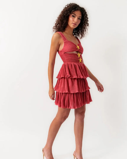 Side profile of women's coral summer mini dress with cut-outs, ruffles, and starfish details, worn with heels.